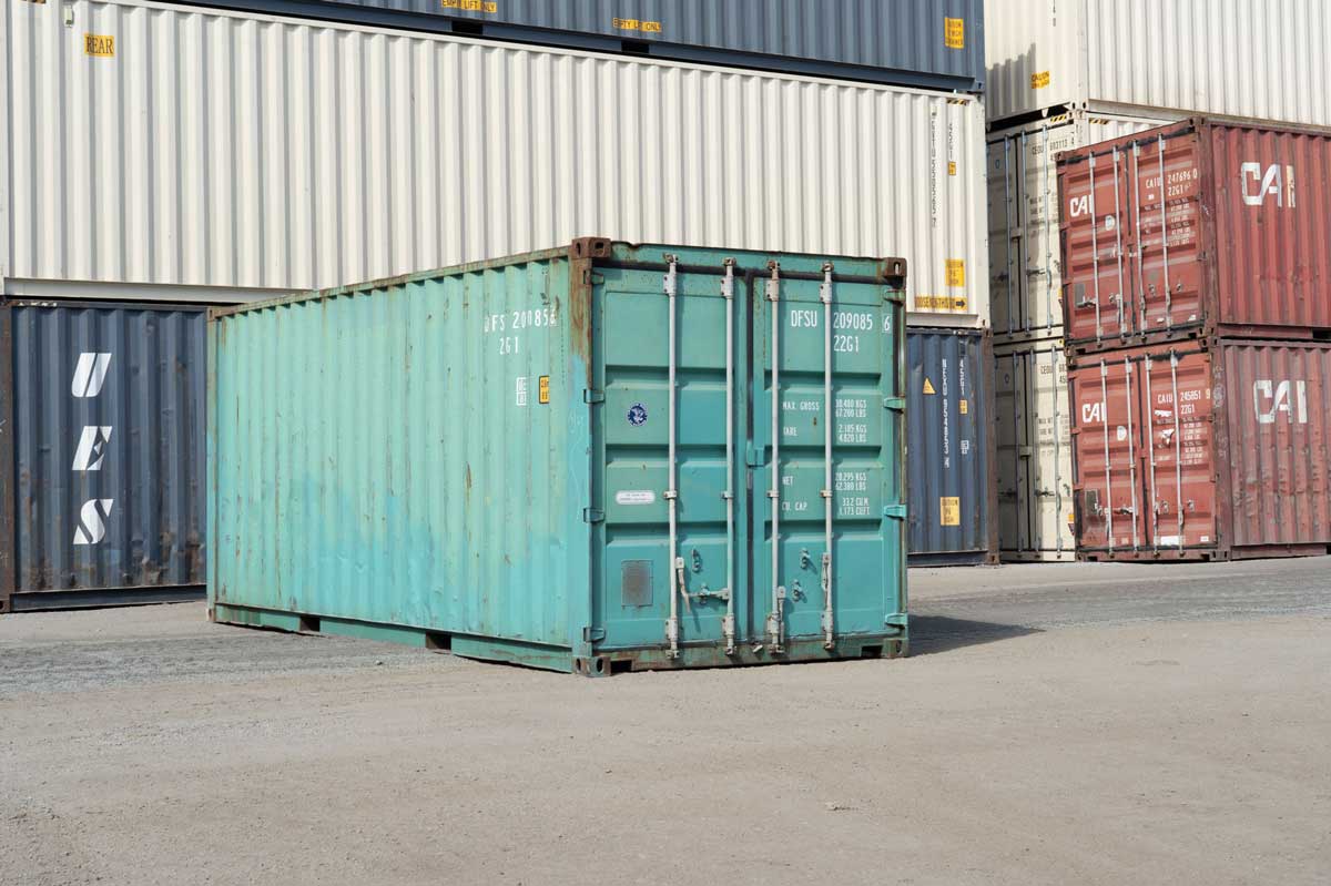 Teal shipping container in a storage yard